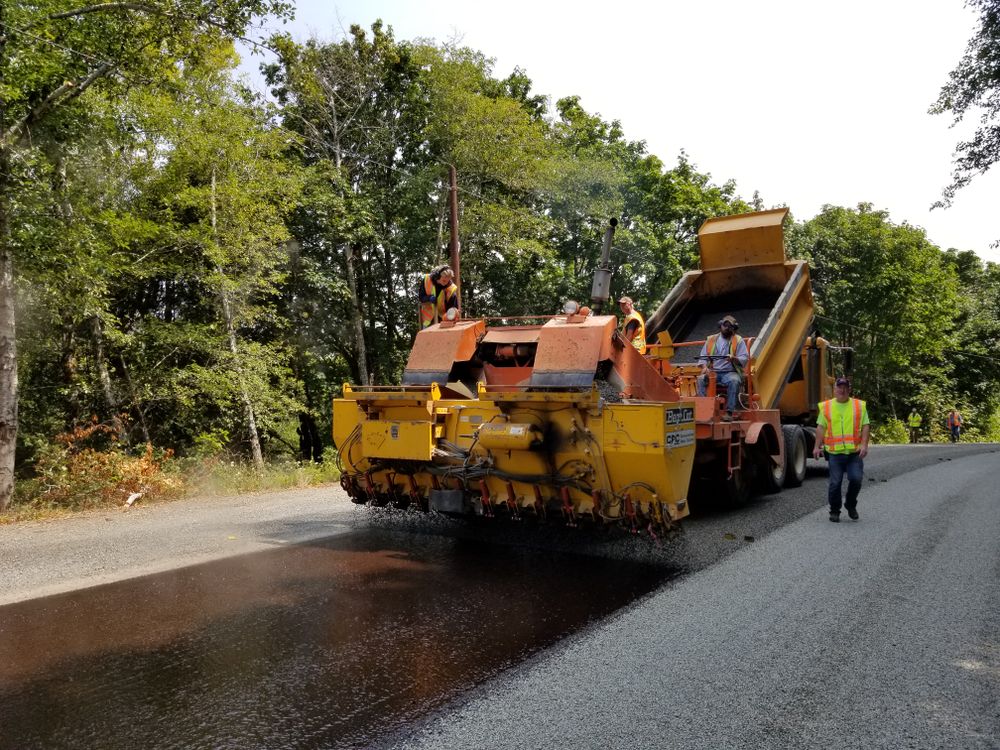 Workers and machinery carrying out road paving